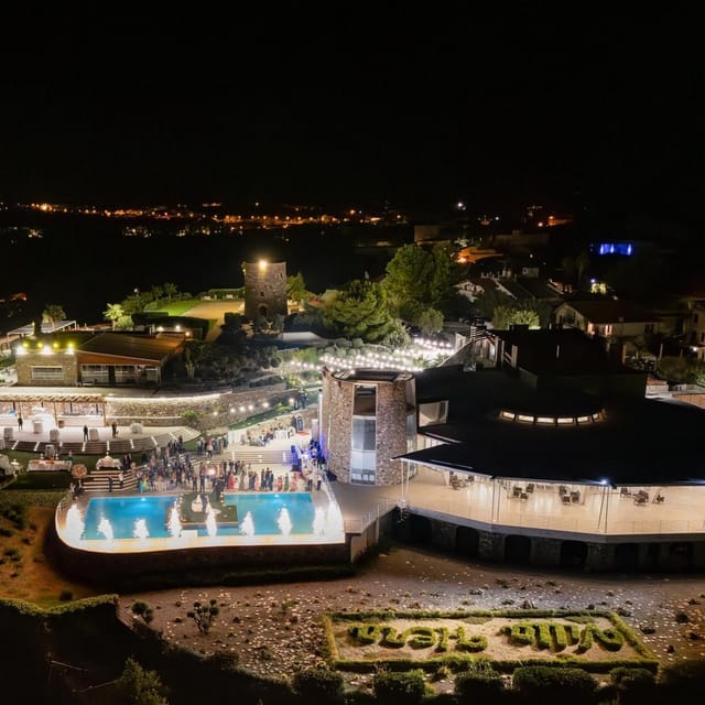 Veduta aerea di Villa Hera di notte, illuminata, sul promontorio di Capo Milazzo.