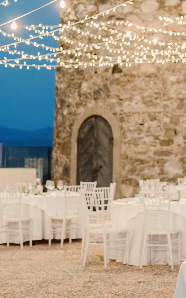 Torre Saracena di Villa Hera all’ora blu, con i tavoli apparecchiati sotto le luci a filo.