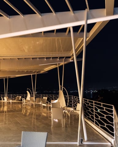 Veranda bioclimatica di Villa Hera illuminata di sera.